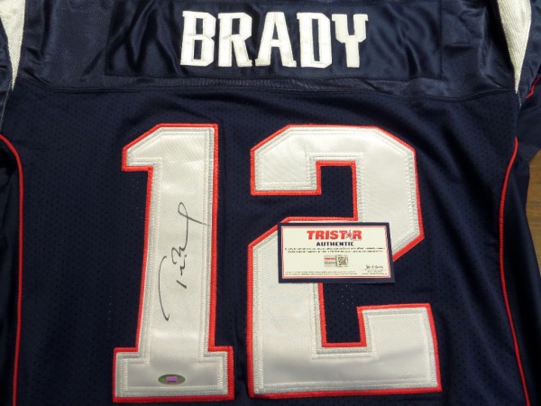 This blue size 52 vintage Reebok New England Patriots authentic style jersey  is still tagged as new, and has everything professionally-sewn in Pats colors.  It is back number-signed in black  sharpie by the all WORLD QB and sure fire future HOF'er himself.  The signature grades an overall 8.5, and the jersey is fully certified by TRISTAR (7752937) for rock solid authenticity.  Valued well into the low thousands with a rock bottom, Crazy Eddie minimum to start us off!