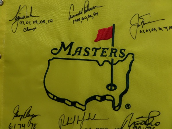 This MINT condition, authentic style yellow Masters pin flag features the Masters logo embroidered, and comes hand-signed all around in black sharpie by no less than SIX PGA greats who have won the famed Augusta major at least three times!  Included are Jack Nicklaus, Arnold Palmer, Gary Player, Tiger Woods, Nick Faldo, and Phil Mickelson, and each golfer has added the years that he won the tournament as an inscription.  NO golf collection would be complete without this crown jewel, valued into the low thousands!