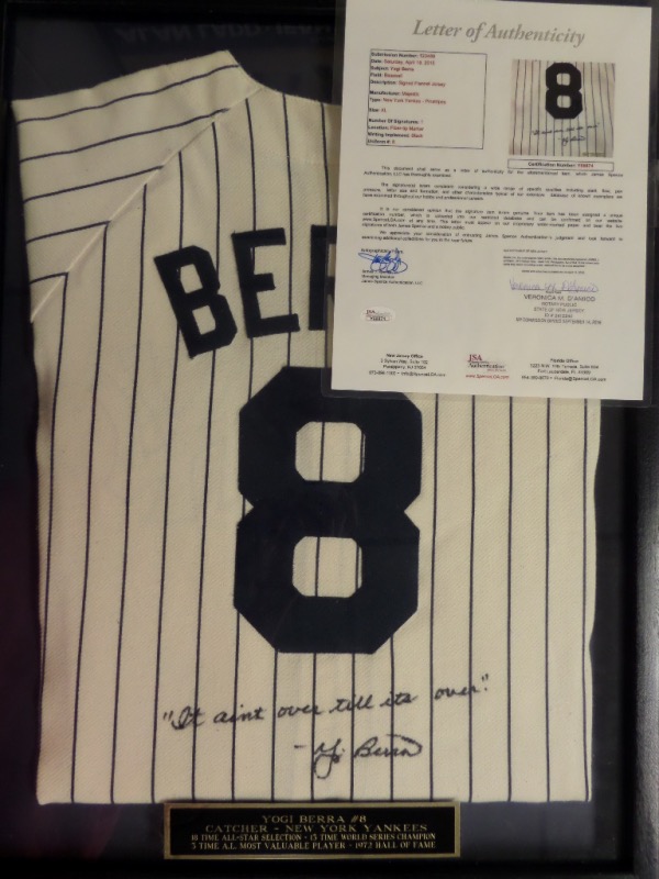 This custom wood framed wall hanging holds a Pro Yankees home white jersey, his retired #8 sewn on back, and comes black sharpie signed with his famous "It Ain't Over" saying. It grades a clean bold 10 all over, has a custom engraved placard along the bottom, and a full Jimmy Spence "JSA" letter and matching hologram intact. No nonsense here, just an easy HOF NYY buy and hold investment with a value at $1600.00, yet sold here at the "Corner" with NO reserve! 