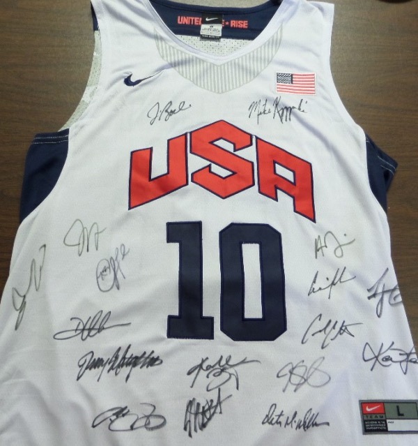 This white size L Kobe Bryant #10 USA Basketball jersey is in NM/MT shape, and comes with everything embroidered.  It is hand-signed on the front in black sharpie by 17 team members and coaches of the gold medal squad, including Kobe himself, Coach K, KD, AD, LeBron and all the rest.  Valued into the low thousands!
