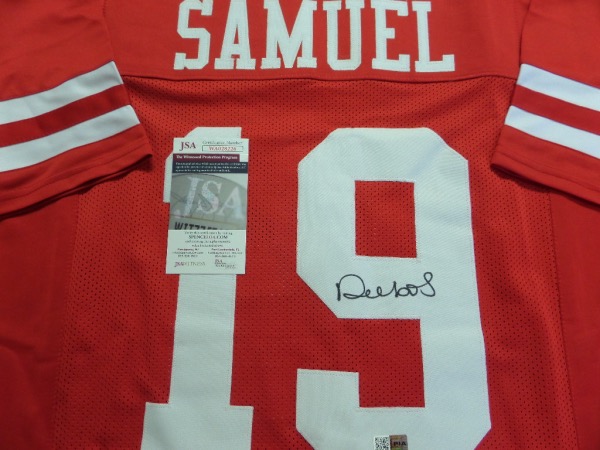 He's one of the hottest receivers in the NFL right now, and now, here is YOUR first chance to own a bit of Deebo!  This red custom 'Niners jersey is trimmed in sewn white, and comes back number-signed by the 2021 All Pro wideout himself.  The black sharpie signature is a clean 9 overall, and comes fully JSA certified (WA028226) for authenticity.  A smoking hot retail item right now, and sales potential for the right dealer is easily a grand, or even higher if you're good enough.  Are you good enough?