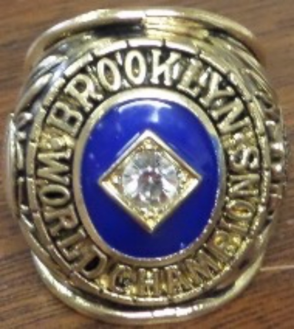 This RARE and gorgeous heavy, well made and good looking ring is a 1955 Brooklyn Dodgers JACKIE ROBINSON World Series Custom Championship ring! The ring is stunning and features one big CZ diamond in the middle along with Brooklyn World Champions on the front around the diamond. The ring also features a baseball on the one side with Jackie Robinson's name in the middle! The ring is a size 11 and is one of the more "rare" Brooklyn Dodgers replica style Championship rings available! Don't let this beauty slip by, as the value of this ring is HIGH! This beautiful and rare ring would make a great addition to any collection, and Truly a Gorgeous Ring
