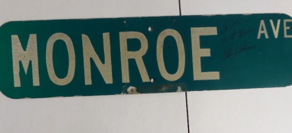 This amazing and completely unique collector's item is one that probably even the most devout Marilyn fans do not have.  It is a green metal street sign, measuring 6x24, reading MONROE AVE, and in EX condition still!  It is hand-signed in black by Ms. Monroe herself, personalized To Joe with Best Wishes, and grading a strong 8 overall.  Can you imagine this piece as part of your Hollywood collection?  WOW!!!