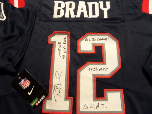 This blue size L Tom Brady #12 New England Patriots football jersey from Nike is still tagged as new, and comes with everything professionally-sewn.  It is back number-signed in black sharpie by the "G.O.A.T." himself, grading an 8, and including Most QB SB Wins EVER, 6x SB Champ, 4X SB MVP and G.O.A.,T.  inscriptions.  A great looking Pats jersey, and with the Brady autograph, retail is low thousands!