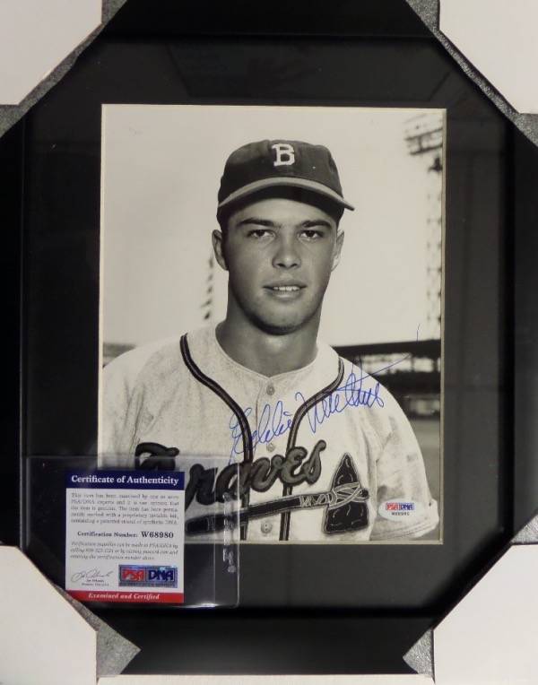 This 13x15" black-framed and matted piece features a black and white photo of a young Eddie Mathews as a member of the Milwaukee Braves.  The photo is hand-signed in blue by the 500 Home Run Club member and deceased HOF 3rd baseman himself, and the piece comes fully PSA/DNA certified (W68980) for authenticity purposes.  Valued into the hundreds!