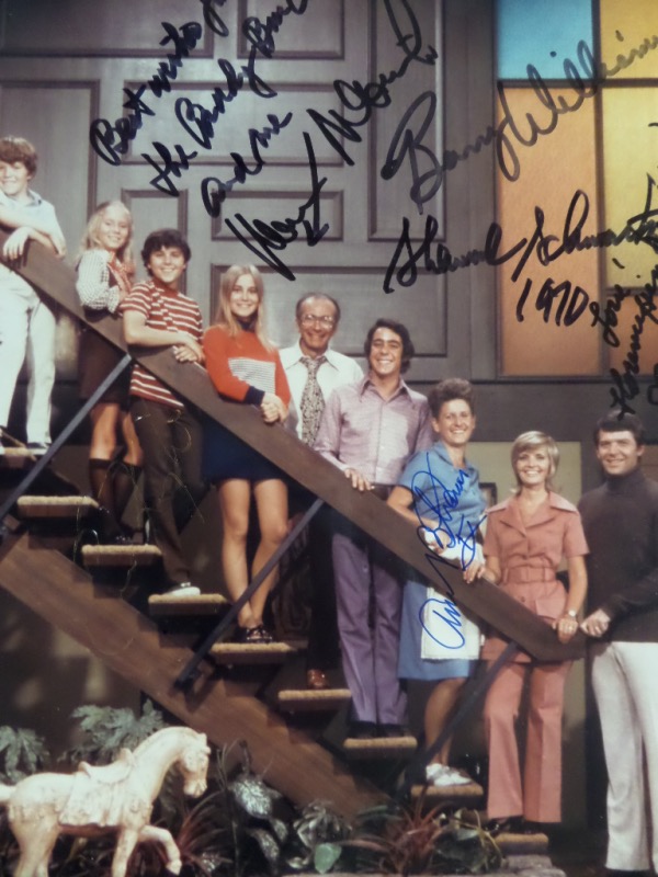 This full color 8x10 photo shows the Brady family standing on the stairs of their home, along with show creator Sherwood Schwartz.  It is autographed by six of those pictured, including Schwartz himself, Ann B. Davis, Florence Henderson, Barry Williams, Chris Knight and Maureen McCormick and this great-looking photo values well into the hundreds!