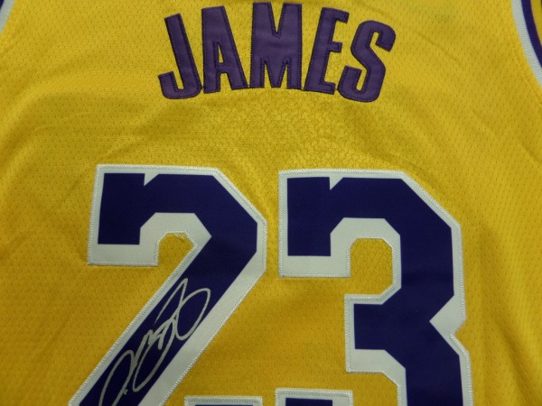 This yellow size 50 LA Lakers jersey from Nike is still tagged as new, and comes trimmed in purple and white, with everything sewn.  It is back number-signed beautifully in bright silver by King James himself, the signature grading a legible 9.  Ideal for framing and display and retail is low thousands!