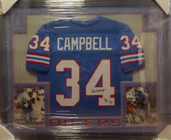 This gigantic custom framed display measures 35.5x43.5, and is professionally hand-done, with double matting, Oilers logos, and color photos.  It houses a beautiful light blue throwback Oilers jersey, hand-signed in black sharpie by all time, all World running back, Earl Campbell.  Signature grades an overall 8.5, complete with a HOF 91 inscription, and the jersey is affixed with a sticker from "JSA" (WP377148) for authenticity.  Ready for display, and valued into the low thousands!