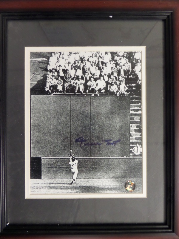 This 13x16 custom framed and double matted display houses a black and white photo.  It is the iconic image of Willie chasing down Vic Wertz's deep fly ball in the 1954 World Series before "magically" hauling it in, and it comes hand-signed in blue sharpie by the Giants HOF great himself.  A hologram has been affixed from Mays' own Say Hey company, and this display-ready piece is valued into the mid/high hundreds!