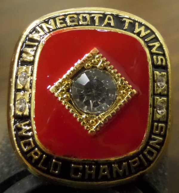 This well made Ring from USA is the exact replica of the 1991 World Championship ring given to Kirby PUCKETT, and is a size 11, and comes with a velvet pouch for protection. The top has "Minnesota Twins World Champions" written on it surrounding a large CZ Diamond, and two smaller ones on each side of the top. The one shank has "PUCKETT" 95-67 their season record, the Twins logo, Kirby's #34. The other shank has "1991" the World Series trophy and 4-3, showing they won the Series in 7 games. Absolutely a GORGEOUS ring, quite RARE to find and well valued from this Deceased HOF'er.