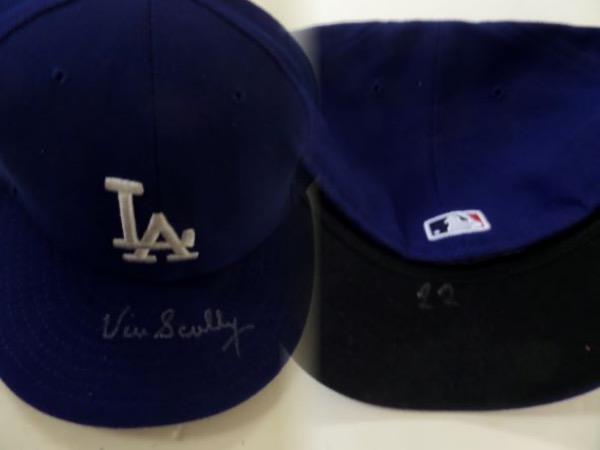 This 7 3/8 fitted blue Los Angeles Dodgers cap has the number 22 inked on the bottom of the bill in black sharpie, suggesting that it was worn IN GAME by future HOF hurler, Clayton Kershaw.  It is hand-signed in silver on the top of the bill by HOF Dodgers announcer, Vin Scully, and with Scully's recent death, retail on this unique piece is mid hundreds!