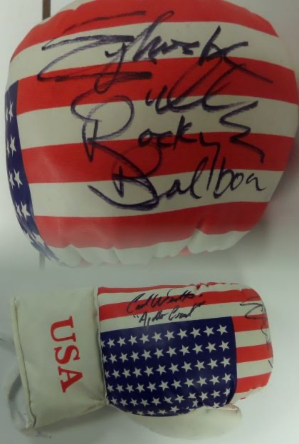 This mint lace-up  ounce 16 ounce glove has the US flag on it and comes signed GORGEOUSLY by both of these ROCKY superstars in black sharpie with Sly including "Rocky Balboa" & Carl including "Apollo Creed" with their autographs! Ideal display glove and guaranteed authentic. Retails in the high hundreds+. Rare.