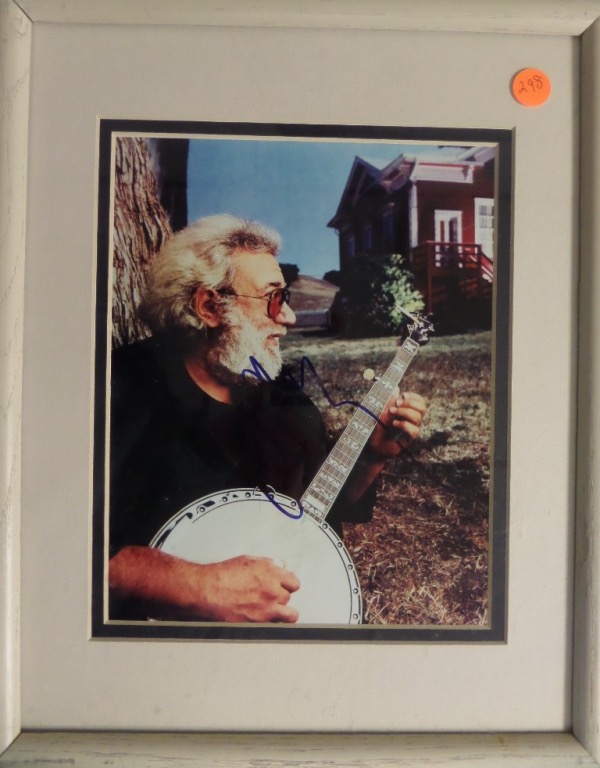 This 12x15 white painted wood framed and black/white double matted display features a color photo of Jerry Garcia, probably in the late '80's to early '90's, playing a banjo.  The photo is hand-signed in blue sharpie by the Grateful Dead guitarist/singer himself, and with his death now approaching 30 years ago, retail is mid hundreds!