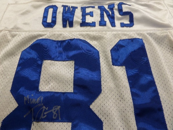 This nicely used and well washed pro jersey is tagged right, his size 50, and has sewn on everything as well as name on back. It comes not only back #81 signed by the difficult HOF pass catcher, but with "MINE" written in his hand as well. Super Canton buy and hold HOF investment, and value is thousands on "T.O.". 