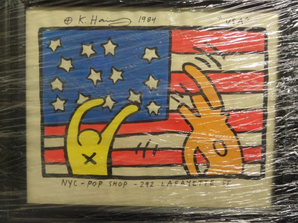 This patriotic piece is a hand painted flag with people, dated and signed from 1984 by the late, great NYC pop star artist, and framed to 11x14 just for you. It is titled "USA" by haring, has his own estates stamps remaining on the back for iron clad authenticity, and value on a hand done work like this is lower thousands. Check him out online, then bid accordingly. 