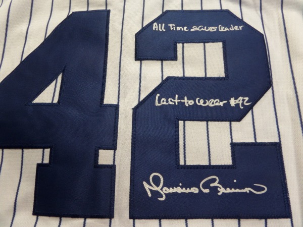 This home white, pinstriped size L NY Yanks jersey from Nike is still tagged as new, and comes to us with everything sewn.  It is back number-signed in bright silver by the greatest closer EVER, complete with the following inscriptions:  All Time Saves Leader and Last to wear #42.  A fantastic NYY item, valued into the mid/high hundreds, especially with these cool inscriptions added!