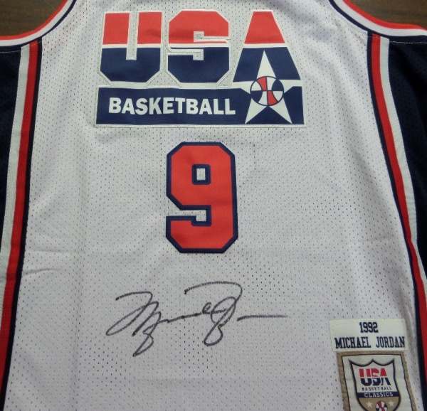 This 1992 model white USA Basketball "Dream Team" #9 Jordan jersey is from Mitchell & Ness, a size 50 with original tagging attached.  It is front-signed in black sharpie by His Airness himself, his HUGE signature grading a strong, clean and legible 9.  A great looking jersey, a MUST for any basketball collection, and retail is very high hundreds!