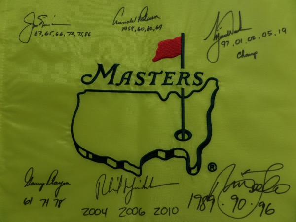 This MINT condition, authentic style yellow Masters pin flag features the Masters logo embroidered, and comes hand-signed all around in black sharpie by no less than SIX PGA greats who have won the famed Augusta major at least three times!  Included are Jack Nicklaus, Arnold Palmer, Gary Player, Tiger Woods, Nick Faldo, and Phil Mickelson, and each golfer has added the years that he won the tournament as an inscription.  NO golf collection would be complete without this crown jewel, valued into the low thousands!