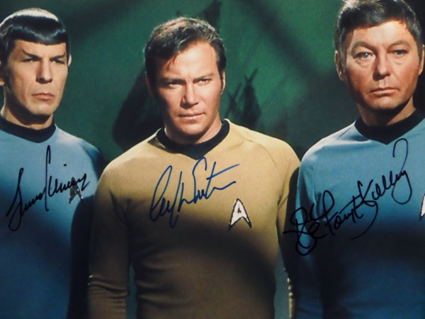 This $1500.00 photo is a glossy color 8x10, shows 3 members of the sci-fi crew from the 1967 TV series, and comes hand signed by William Shatner, Leonard Nimoy and DeForest Kelley. It grades a clean bold 10 all over, shows off well from 20 feet away, and as always, we'll sell it with NO reserve! 