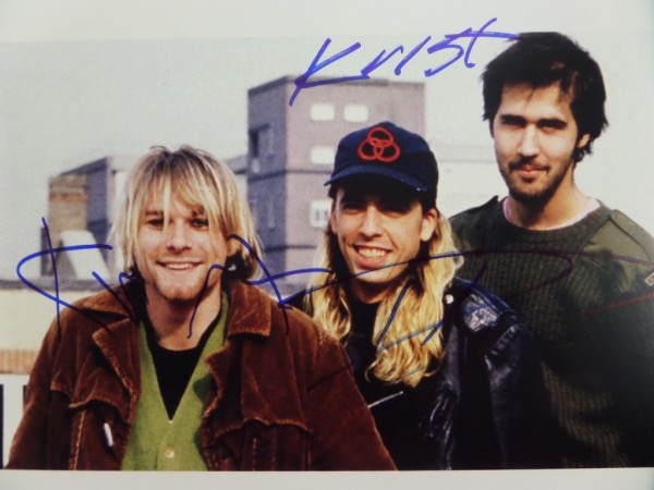 This full color 8.5x11 photo shows all three members of Nirvana in the early 1990's.  It is hand-signed in blue sharpie by all three, including Krist Novelesic, Dave Grohl, and Kurt Cobain, and with Cobain's tragic death now nearly 3 decades ago, retail here is well into the hundreds!