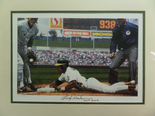 This artist signed Bill Purdhom work is custom double matted to 16x20 in green and white Oakland team colors, and holds a limited edition HOF sold artwork of Rickey swiping his 939th base. It is IN PERSON signed, his HOF Induction year added, and features our world famous lifetime guarantee! It is a 10 all over, value is upper hundreds, and we don't care if you send it to JSA, PSA or whomever...