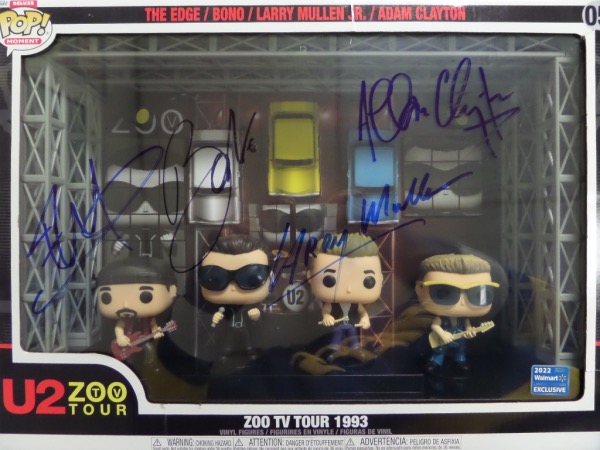 This large, mint boxed set holds FOUR Funko's, one each for Bono, the Edge, Adam and the other bandmate, and the front cellophane comes signed by everyone in large, bold blue sharpie. It is a super nice unreal rock n' roll display and collectible, and could possibly be a rare one of a kind with all four signing. High value and show on the roof from a 1993 Zoo TV Tour-Wow!!