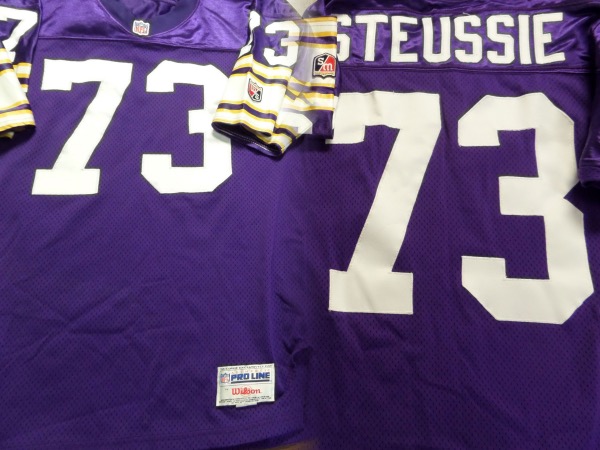 This big time game worn jersey is from #73 Steussie, and shows nice wear and washings evident. It is a Minnesota road purple, trimmed in team white and gold colors, and with sewn on everything as well as name on back. It is tagged right by Wilson in the waist, and as a Pro-Line size 50. Great chance, and value is mid-hundreds. He was a college standout, drafted #19, and a 2-time Pro-Bowl selection as well. 