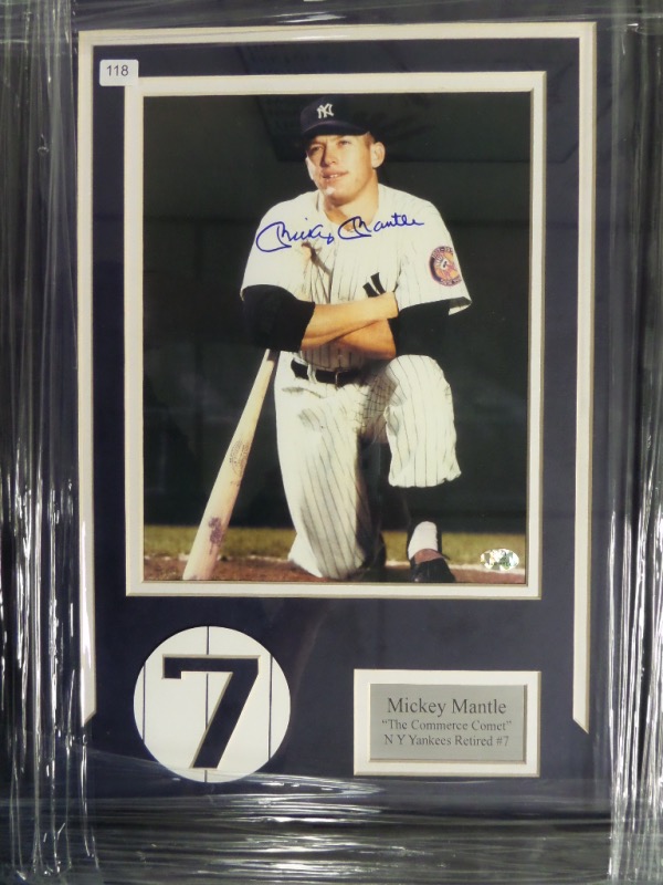 This approximately 16x20 beautifully framed and double matted display features a Yankees #7 logo, a custom silver metal nameplate, and a color photo that is hand-signed in blue sharpie by the all time great himself.  Signature is a clean, perfect 10, and this display-ready piece is fully STAT certified to boot!  Retail is high hundreds!