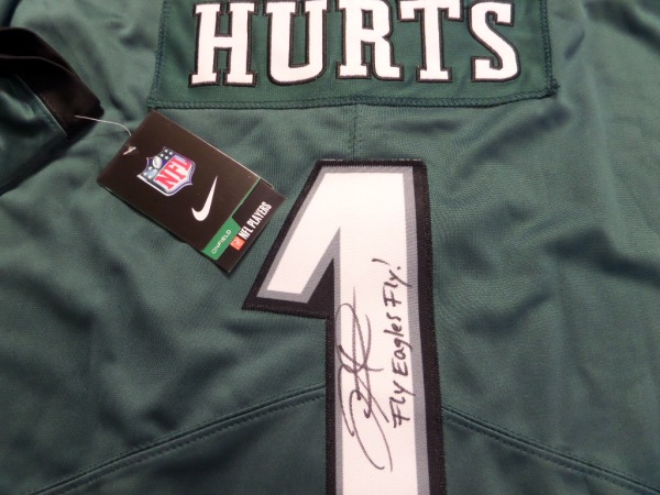 This green size L Hurts #1 Philadelphia Eagles football jersey is from Nike and comes with original tagging attached.  It has everything sewn, and is back number-signed by the up and coming Eagles QB.  The signature grades an overall 8.5, including Fly Eagles Fly! inscription, and retail on this item is smoking hot right now, especially with football season just around the corner!