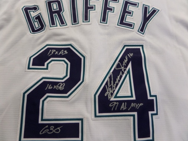 This home white size L Seattle Mariners jersey is trimmed in green, blue and silver, and comes with everything professionally hand-stitched.  It is back number-signed in bright silver on the back number by the HOF great himself, including 16X GG, HOF 16, 13X AS, 630, and 97 AL MVP inscriptions.  A super duper unique collector's item, and retail is very high hundreds!