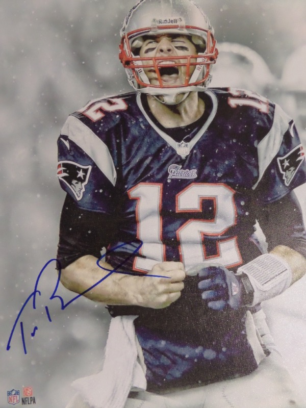 This large 22x28 sized real canvas work shows the NFL Star in a snowy winter Foxboro pose, comes hand signed in bold blue marker, and shows off well from across our auction room. Value is thousands on this must have and must frame work, and of course is team colors are all over the place. 