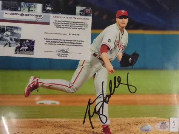 This full color 8x10 photo shows Phillies/Blue Jays HOF hurler Roy Halladay following through on what no doubt was a strike, while pitching for the Phils.  It is hand-signed in black sharpie by the 2 time Cy winner himself, grading about an 8.5 overall, and the photo includes an ACE COA (B18379) as well as a hologram from Sports Memorabilia.com (147133) for serious authenticity.  With this all time great no longer with us, retail, even on an 8x10, is high hundreds!