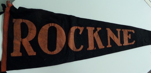 This black felt pennant measures right around 30" in length, and is trimmed in orange, reading ROCKNE across the entire pennant.  It is VERY old, but still intact, and we'd say in F+/G overall condition.  We honestly do not know the provenance of this item, as the colors would suggest that it was not affiliated with Notre Dame.  My limited research yielded exactly zero pennants like this one, which could mean that it is very rare.  If you can research well, you might just be able to steal this one!