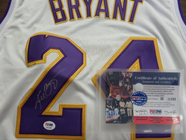 This mint home white style comes trimmed in team gold and purple, has sewn on everything as well as name on back, and comes silver paint pen signed by the deceased NBA HOF Great. It has a numbered PSA/DNA hologram and COA intact, and value is almost 2 grand on the LA Legend. Oh yah..his full name is signed...Cha-Ching!!!!!!