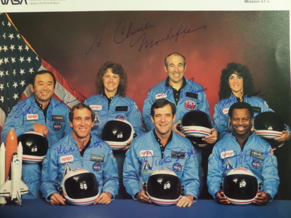 This amazing collector's item is a full 8x10 color NASA photo of all seven members of the "Challenger" mission, all of whom died tragically in the take off explosion.  It is hand-signed in blue ink by all seven, including McAuliffe, Jarvis, McNain, Onizuka, Resnik, Smith and Scabee and this piece values well into the thousands!