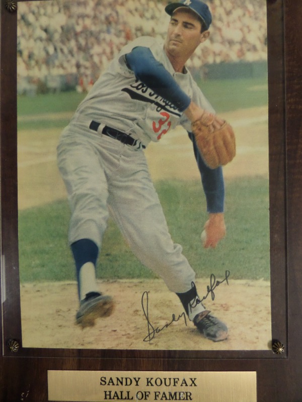 This custom piece is a Stacks of Plaques 1990 era item, real wood, and about 12x15 in size with their sticker adhered to the back for authenticity. It holds a rare color image of Koufax in action, comes black marker signed in a lower corner, and value with 100% certainty is upper hundreds on the reclusive HOF Great, approaching 90 years old. 