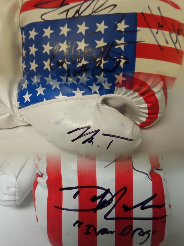 This unique item is a mint USA flag 14 oz. boxing glove that comes signed wonderfully in black sharpie by 5 stars from the legendary Rocky movie and sequels. Included are Sylvester Stallone and 4 of his opponents over the years. Included are Carl Weathers, Mr.T, Dolph Lundgren, & Hulk Hogan!!  A MUST for the boxing fan and even some of their character names included by the legends!
