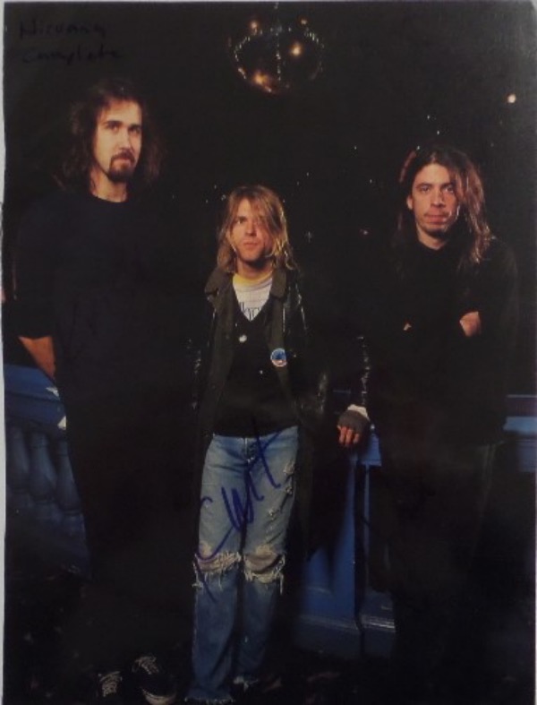 This full color 8x11 magazine photo shows all three members of Nirvana in the early 1990's.  It is hand-signed in blue/black sharpie by all three, including Krist Novelesic, Dave Grohl, and Kurt Cobain, and with Cobain's tragic death now nearly 3 decades ago, retail here is well into the hundreds!