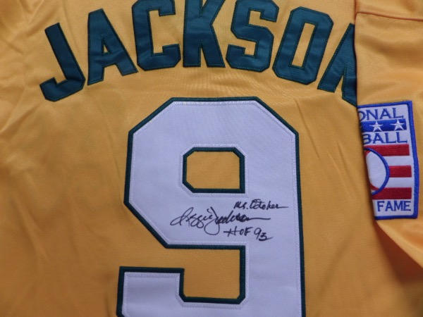 This 1968 Reggie Jackson #9 yellow throwback A's jersey from M&N is a size L that still has original tagging attached.  It is back number-signed in black sharpie by the legendary slugger himself, grading a legible 8, and including Mr. October and HOF 93 inscriptions.  A wonderful and colorful display jersey from a super successful time in A's history, and retail is high hundreds!