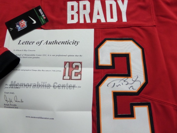 This red size L Tampa Bay Bucs #12 Tom Brady jersey is from Nike, and comes with original tagging attached.  It has everything sewn, and is back number-signed in black by the future HOF passer himself.  The signature is a nice 8 at least, comes certified by The Joe DiMaggio Estate, and retail right now is THOUSANDS on this jewel!