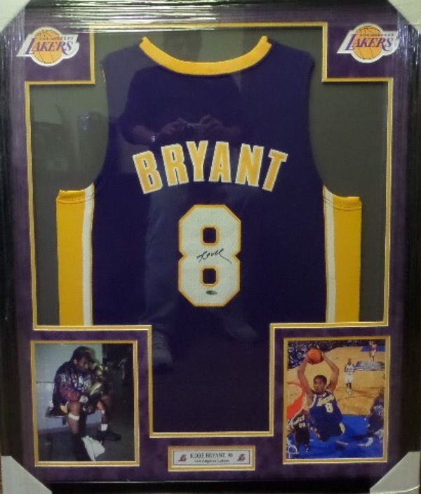 This spectacular display is 3x4 FEET in size, and comes custom triple matted in gold purple and white Lakers team colors. It has 4 custom cutouts, but the main piece is an INPerson Authentics hologrammed game jersey from Kobe. It is signed in bold black sharpie, has Lee's added ok for certainty, and shows off well from a football field away!  Great investment chance, and we'll guess value at $12,000 after PRO framing.