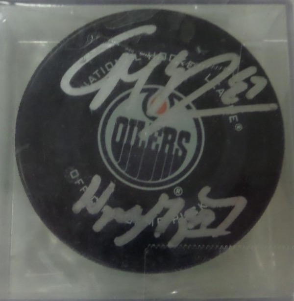 This Edmonton Oilers team logo puck is encased in NM condition, and comes silver sharpie-signed not only by The Great One, Wayne Gretzky, but also by today's greatest player, the incomparable Connor McDavid.  Signatures are strong, legible 8's or better, and retail is high hundreds!