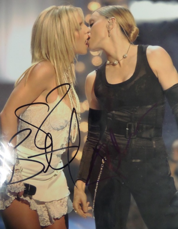 This 2004 color 8x10 shows both pop stars on stage, at the MTV Music Awards and embraced in a kiss. Great TV moment, very risque, and hand signed by both in bold blue/black sharpie. It grades as new all over, an honest, clean 10, and begs for your framing touch to be complete. 