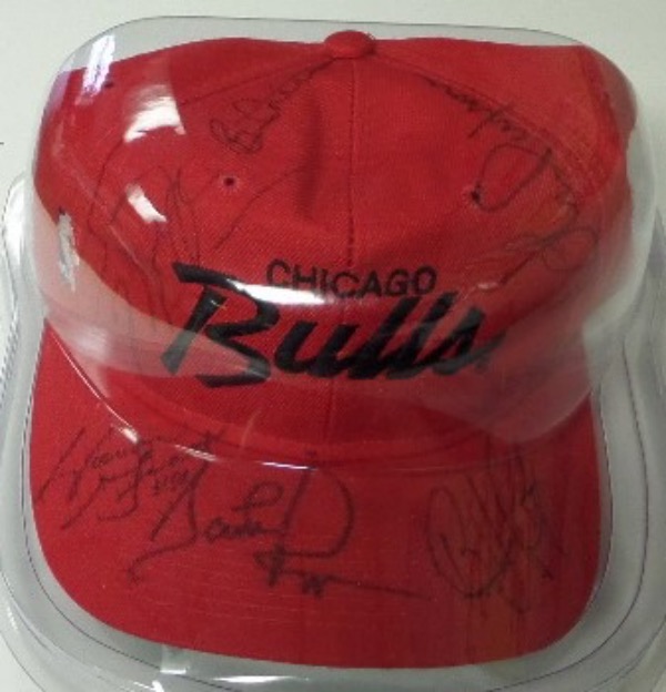 This red Chicago Bulls team logo baseball cap is in NM condition, and comes hand-signed in black sharpie by 6 different key players from their 1991-93 "threepeat" of championships.  Included are Michael Jordan, Scottie Pippen, Horace Grant, John Paxson, BJ Armstrong and Bill Cartwright.  AWESOME memento from the great Jordan years, and retail is mid/high hundreds!