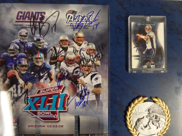 This 12x15 blue colored plaque display features a full color 8x10 Super Bowl XLII print that is hand-signed by ALL pictured.  Included are Patriots stars Tom Brady, Wes Welker, Tedy Bruschi, Randy Moss and Laurence Maroney, as well as Giants stars Eli Manning, Michael Strahan, Osi Umenyiora, Brandon Jacobs and Plaxico Burress.  There is even a FB card signed by Brady as a bonus, and this display-ready plaque is valued at $1099.99!!!