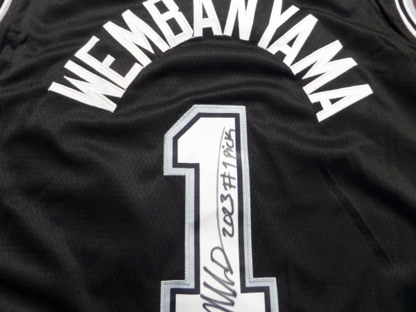 This is the one you've been waiting for!  It is a black size 50 San Antonio Spurs #1 Wembanyama jersey from Nike, still new with original tagging, and back number-signed in bold black sharpie by the highly-anticipated big man.  Signature grades an overall 8.5, complete with a 2023 #1 PICK inscription, and retail right now is actually into the thousands!