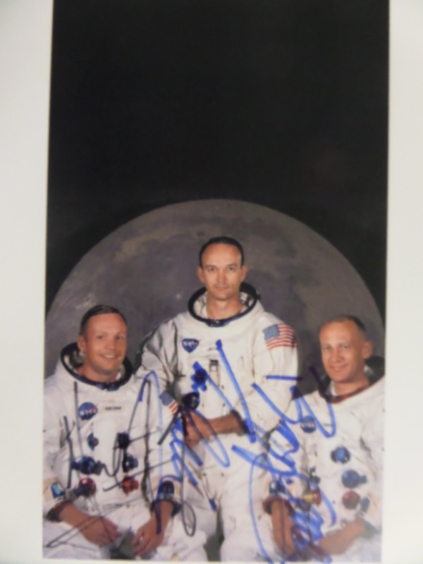 This full color 8.5x11 photograph shows the crew of famed 1969 mission, Apollo 11.  It is hand-signed in blue/black sharpie by all three, including Neil Armstrong (dec), Michael Collins, and Buzz Aldrin.  A perfect 8x10 size for framing and display, and with all three signatures present, valued well into the hundreds!