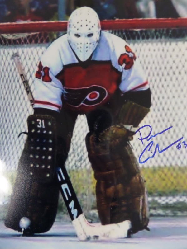 This 1980's color 8x10 shows the star goalie of the Phila. Flyers, and in action inside the net. He was killed in a high speed Porsche car crash many years ago, his signatures are very rare, and very sought after!!! This color 8x10 is signed in bold blue sharpie, on a great spot, and should sell for mid-to-upper hundreds easily. We have never seen, nor sold one in our 30+ years on the auction circuit! 