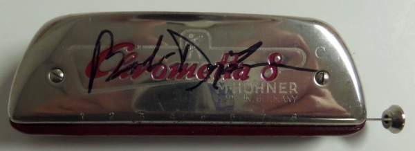 This EX silver Chrometta 8 harmonica from Hohner comes signed on the top superbly in black sharpie by this award-winning singer and songwriter.  The great display item is ideal for the music collector.  Nice and rare.