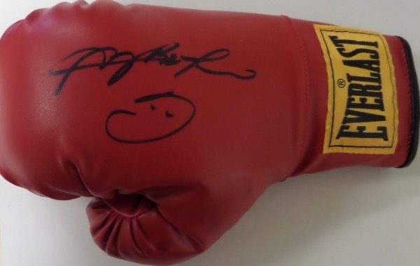 This red slip on style boxing glove is from Everlast, and comes hand-signed in black sharpie by all time great and HOF'er Sugar Ray Leonard.  The signature grades a strong, legible 8.5, with his standard smiley face drawn on, and this baby will show off brilliantly upon display.  Valued well into the hundreds and a MUST for any boxing collection!